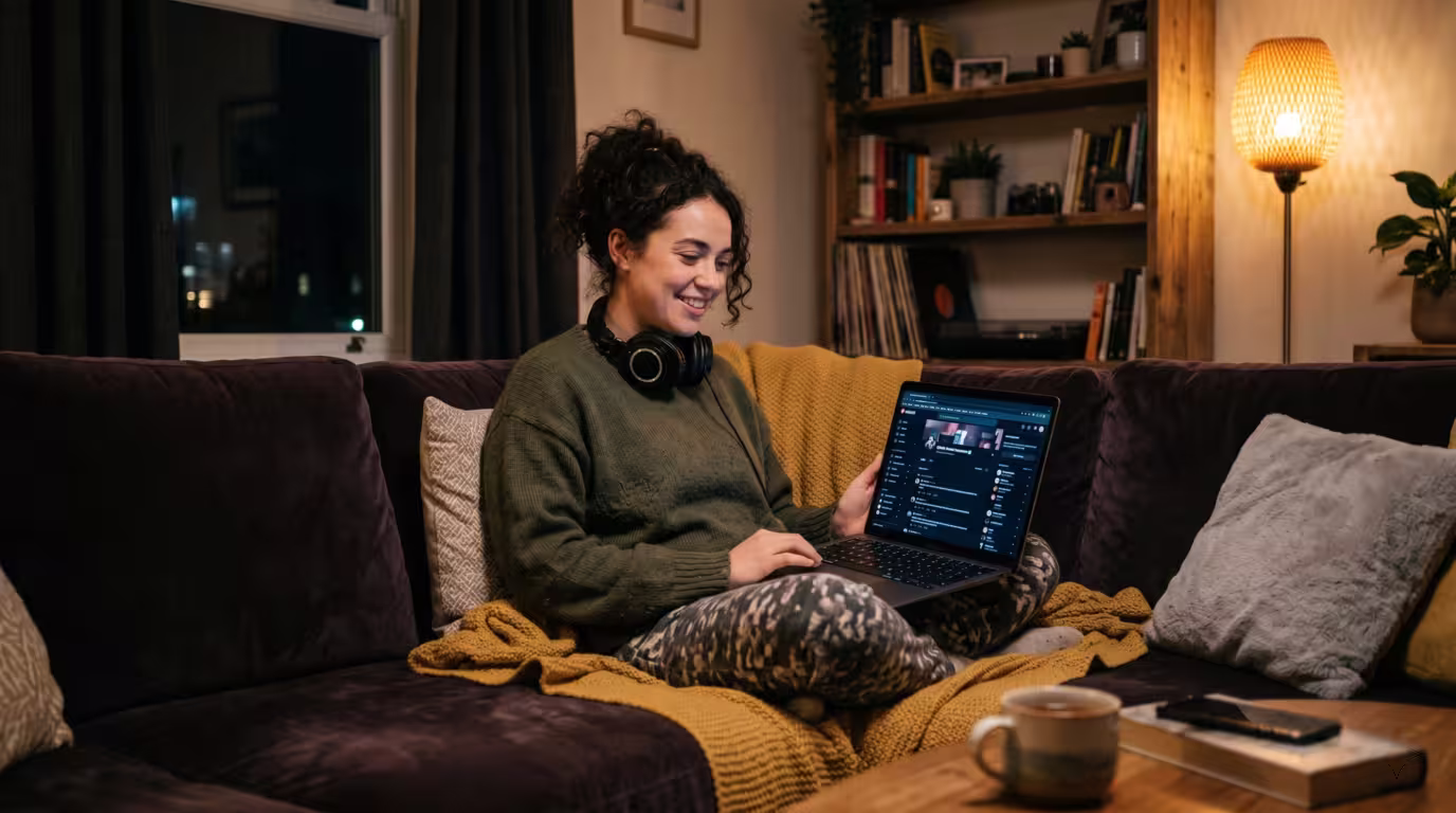 A producer engaging with an online music community on a laptop at home